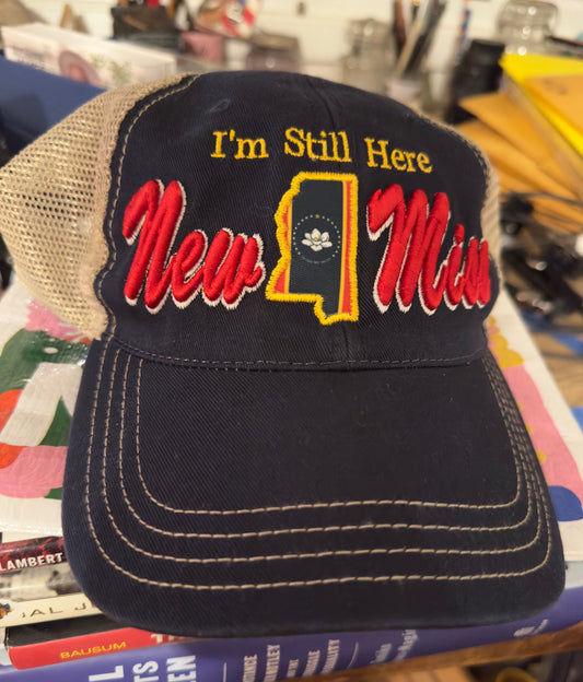 with I'm Still Here and MS State Flag=Limited Edition Navy Blue New Miss Curved brim  Trucker hat with tan mesh back- unstructured fit